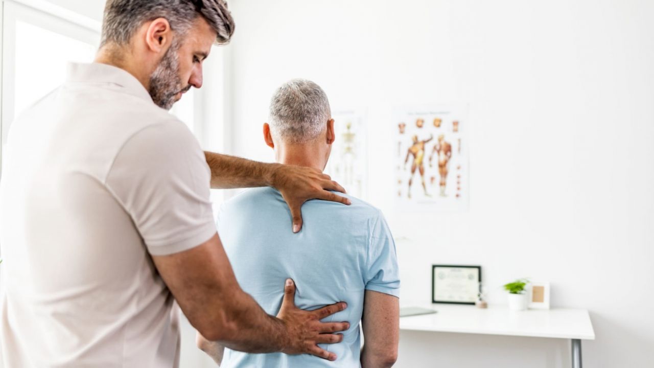 Homem sendo atendido por fisioterapeuta por conta de dor na lombar